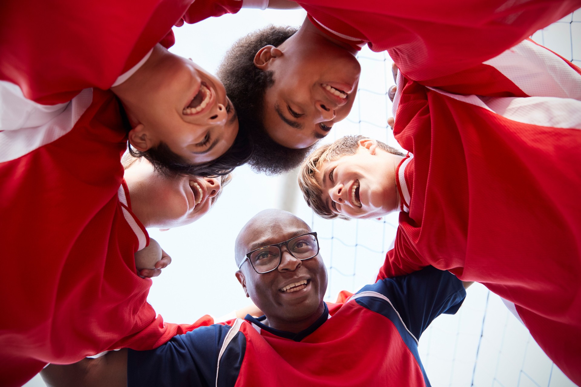 Low Angle View Of Male High School Soccer Players And Coach Having Team Talk