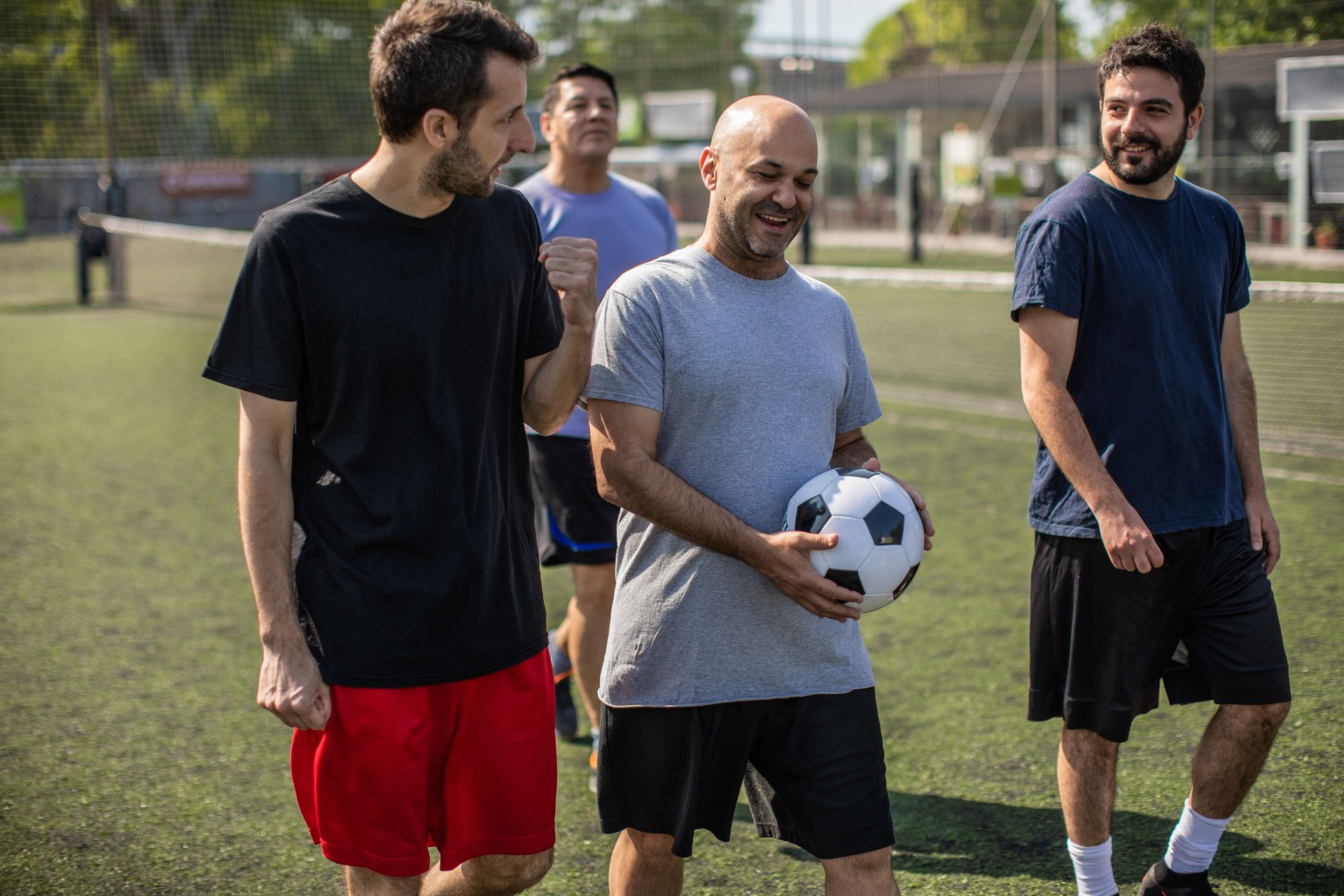 Male friends enjoying time together at sports court during sunny weekend day