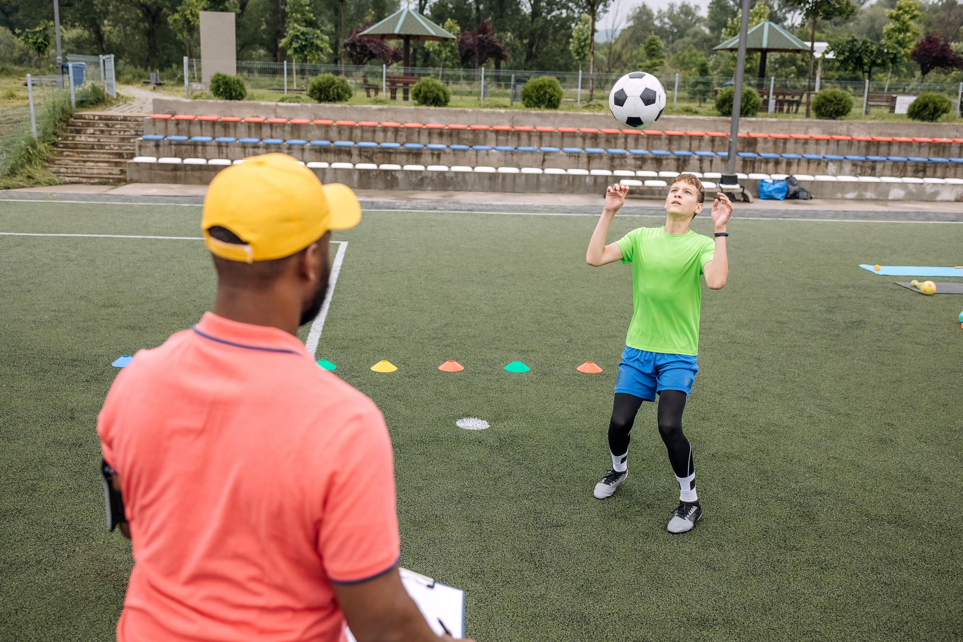 Boy having individual soccer training by the black coach