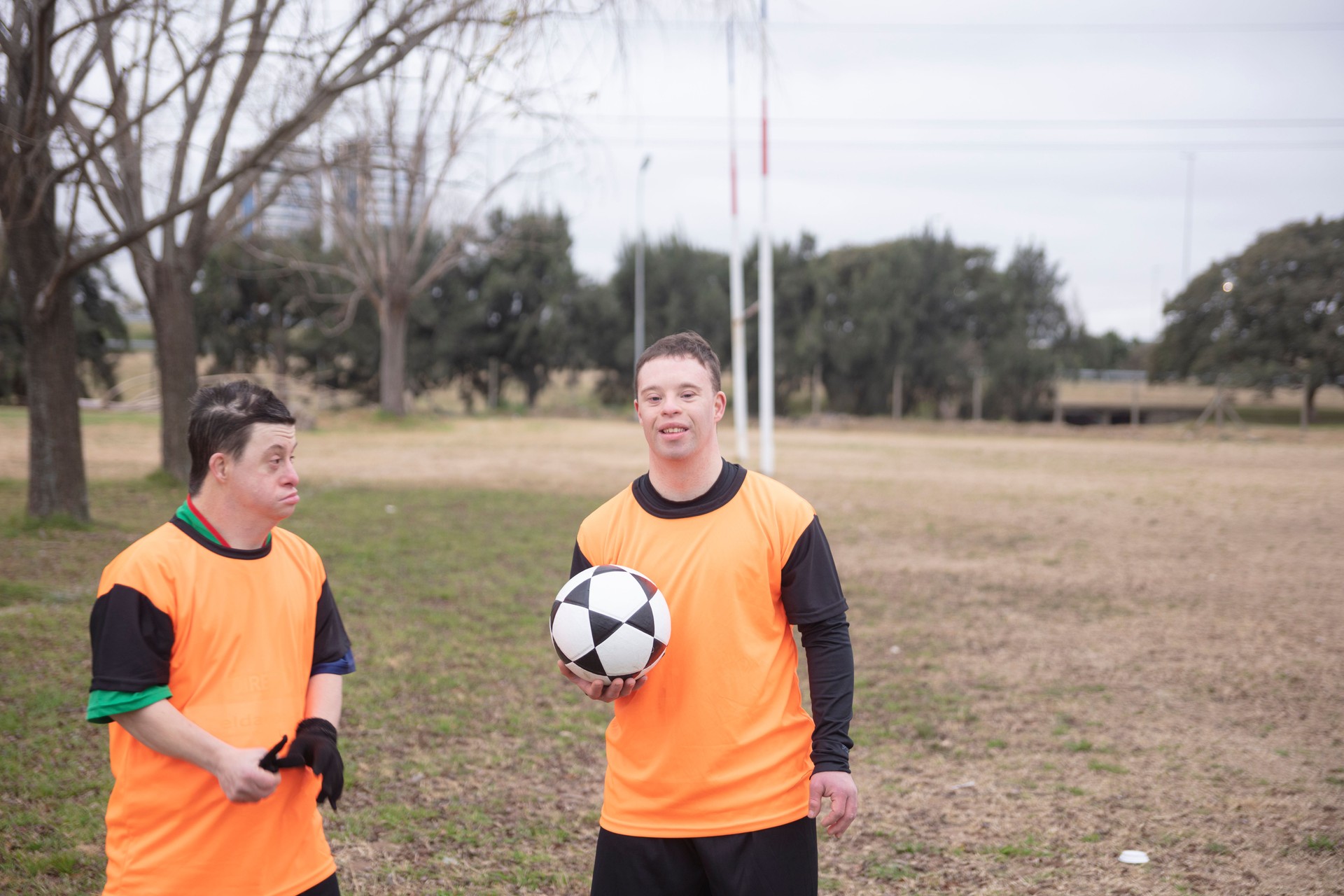 Portrait of two soccer players with down syndrome at field