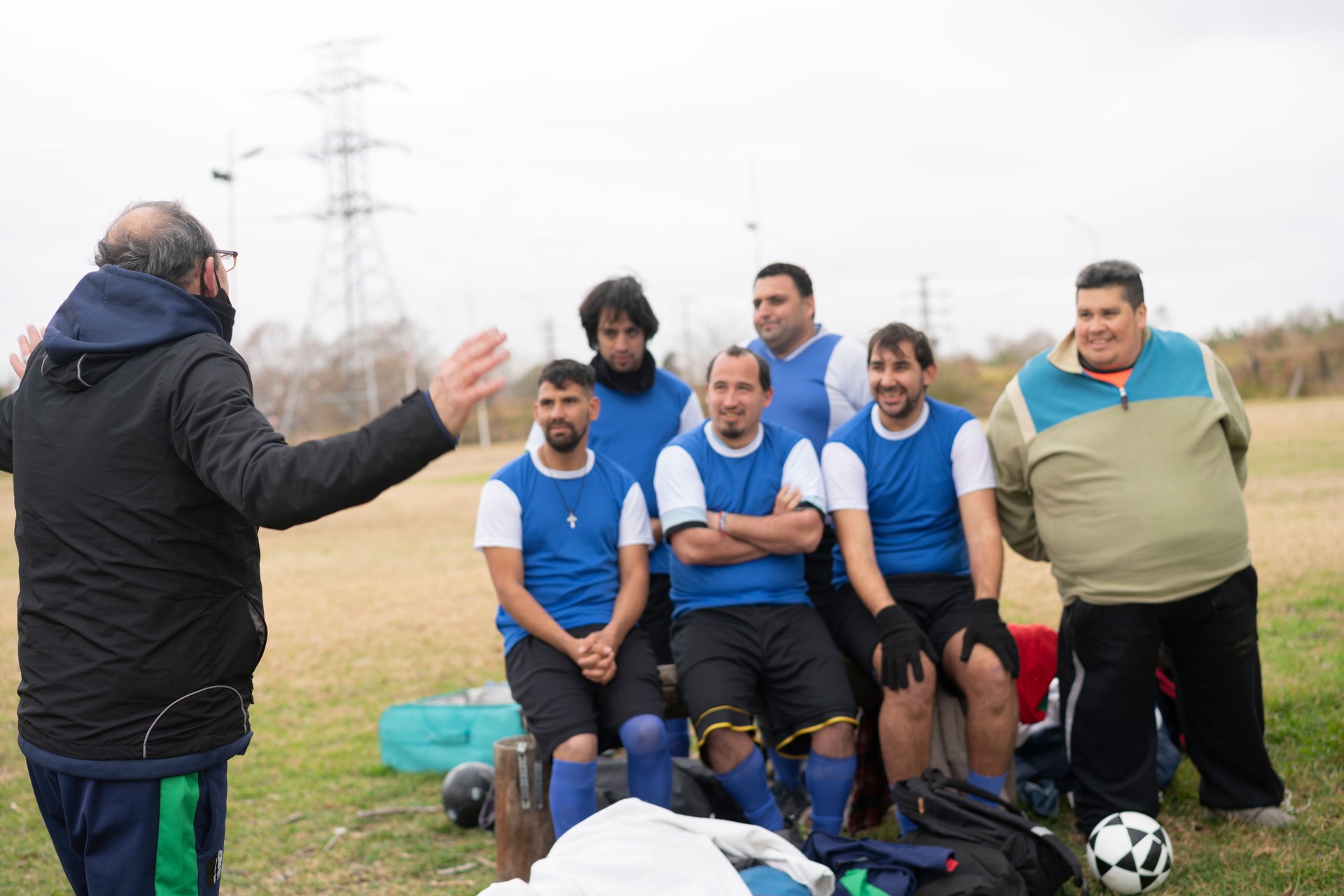 Team of mentally disabled soccer players being coached at field