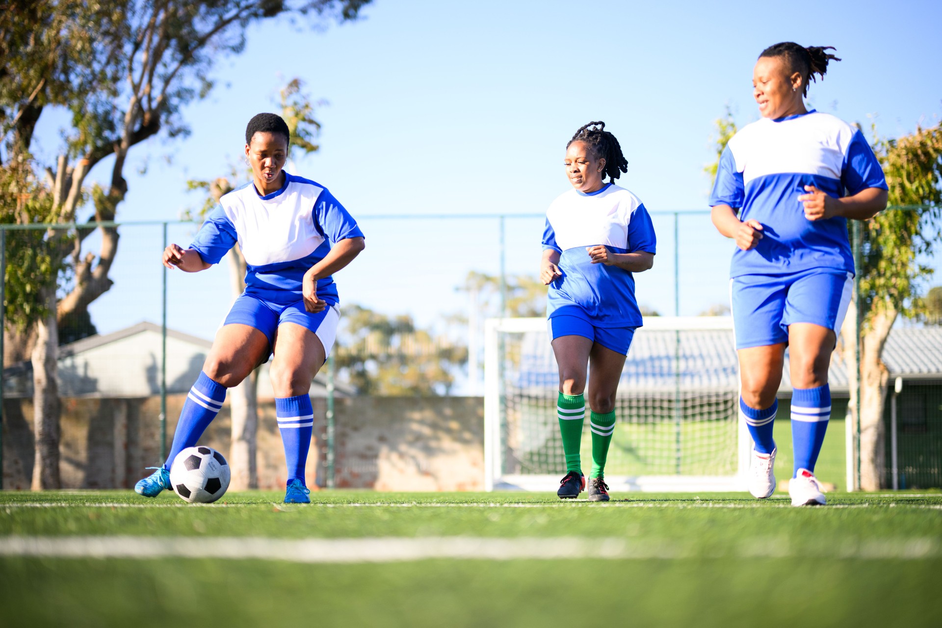 Female football players pass ball practicing